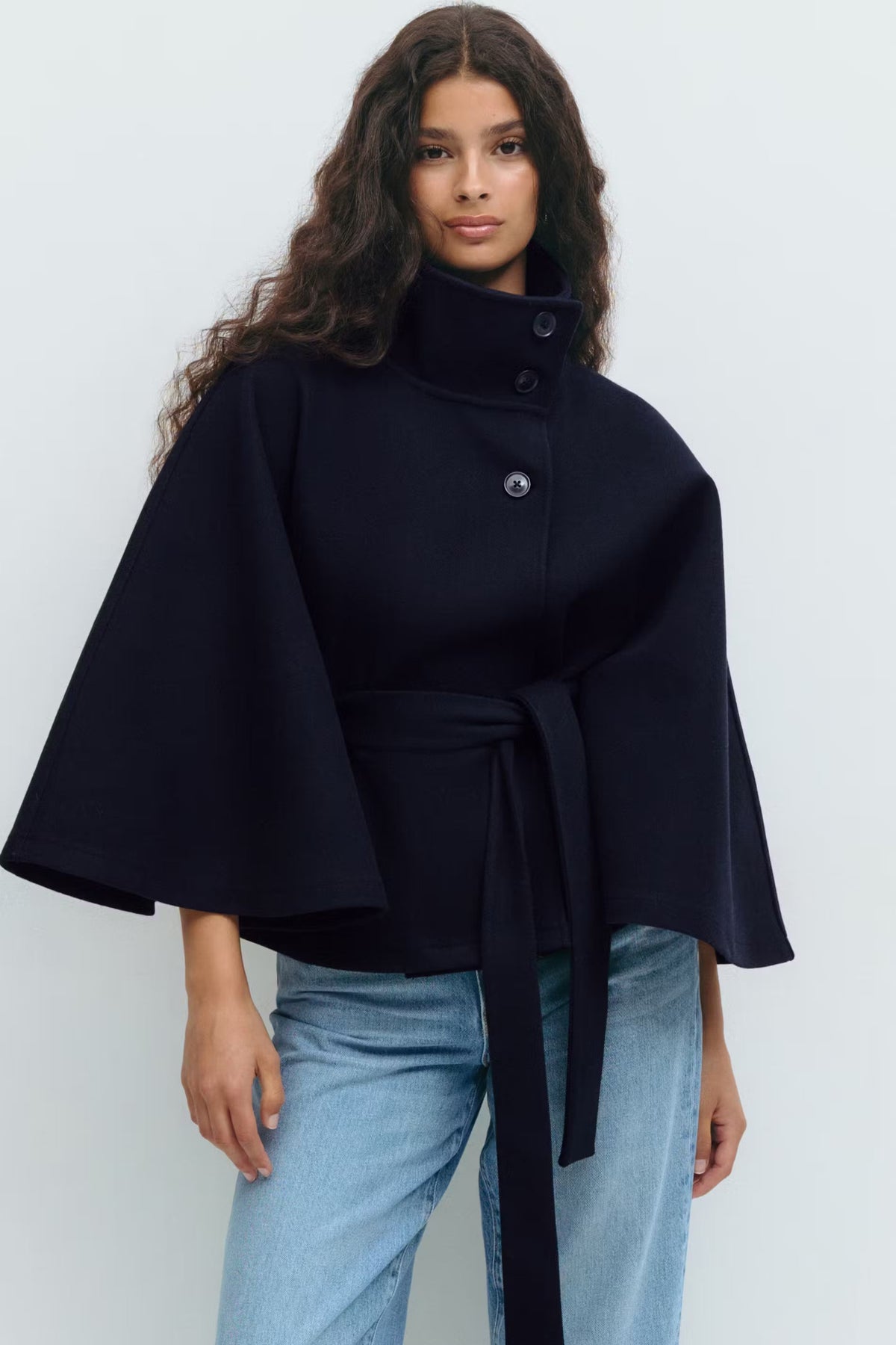 Women’s cape coat with high collar, tie belt, and regular fit