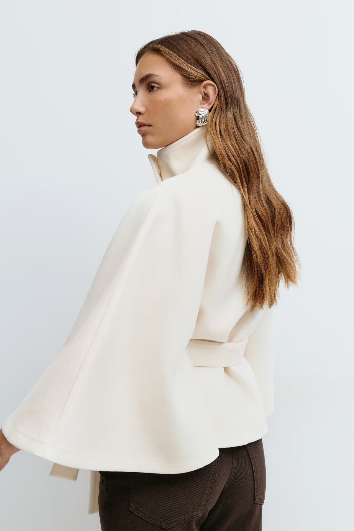 Women’s cape coat with high collar, tie belt, and regular fit