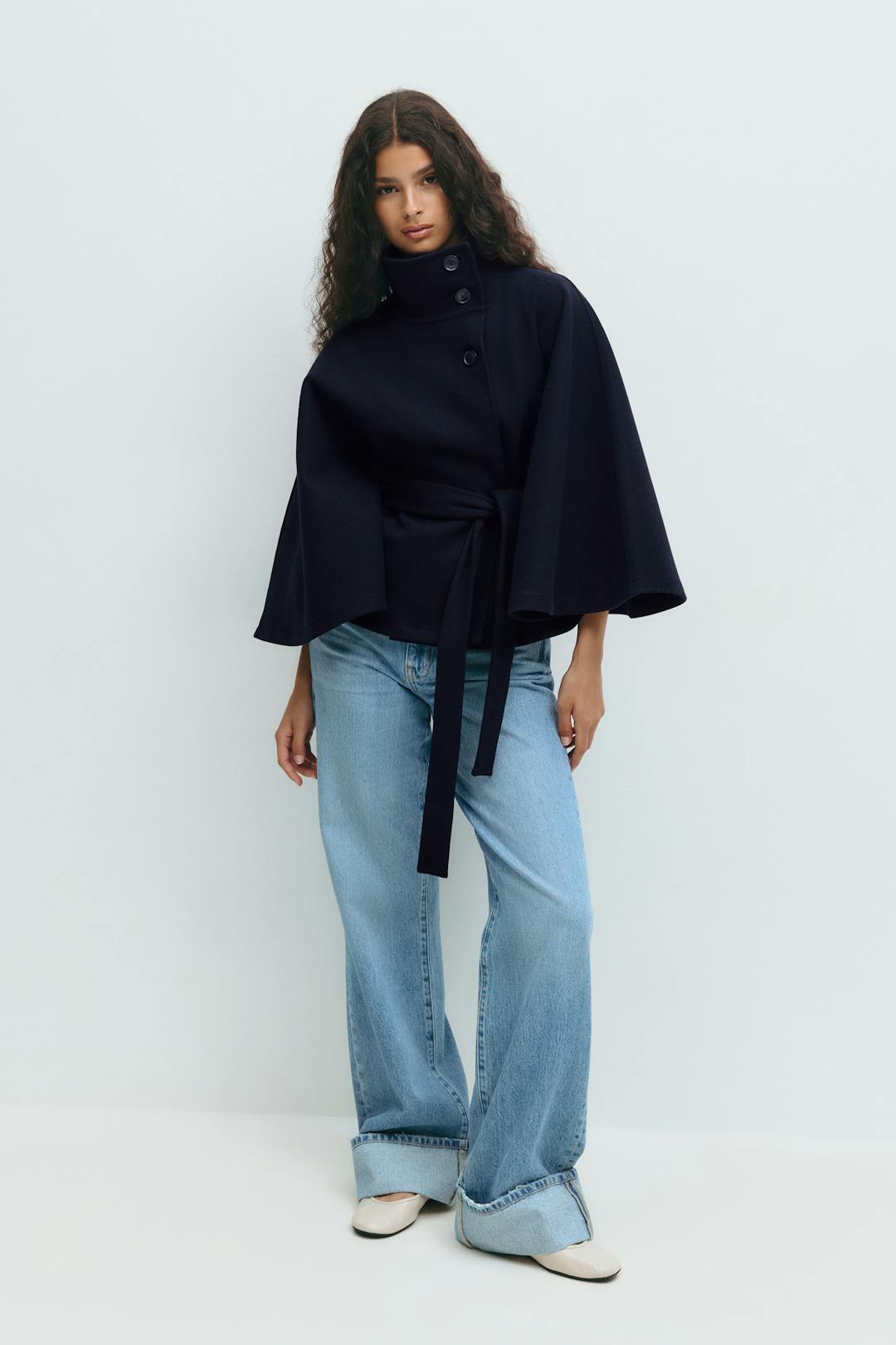 Women’s cape coat with high collar, tie belt, and regular fit