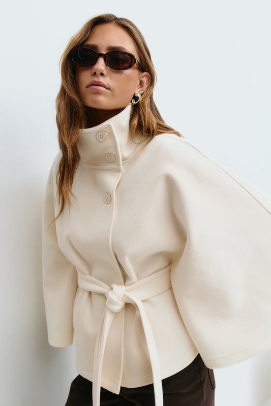 Women’s cape coat with high collar, tie belt, and regular fit