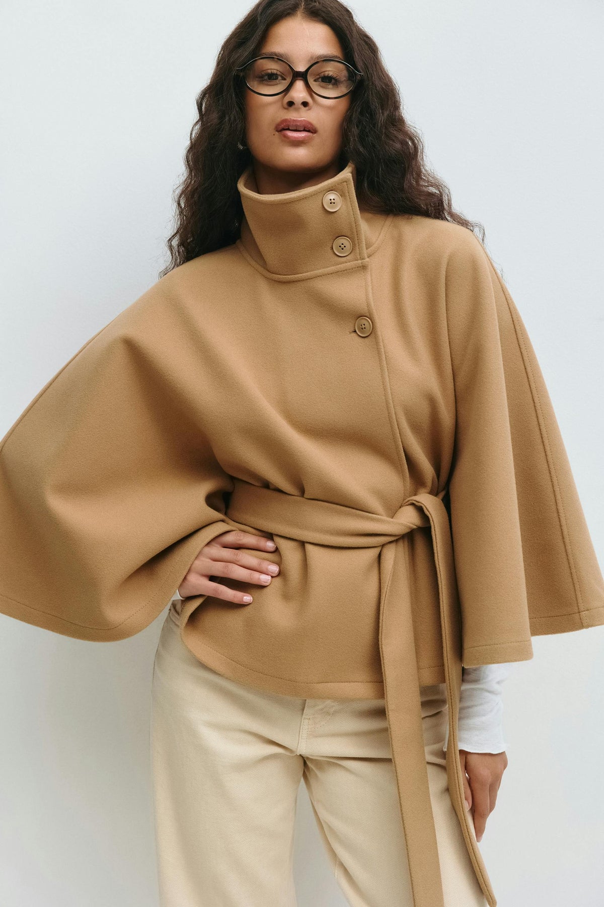 Women’s cape coat with high collar, tie belt, and regular fit