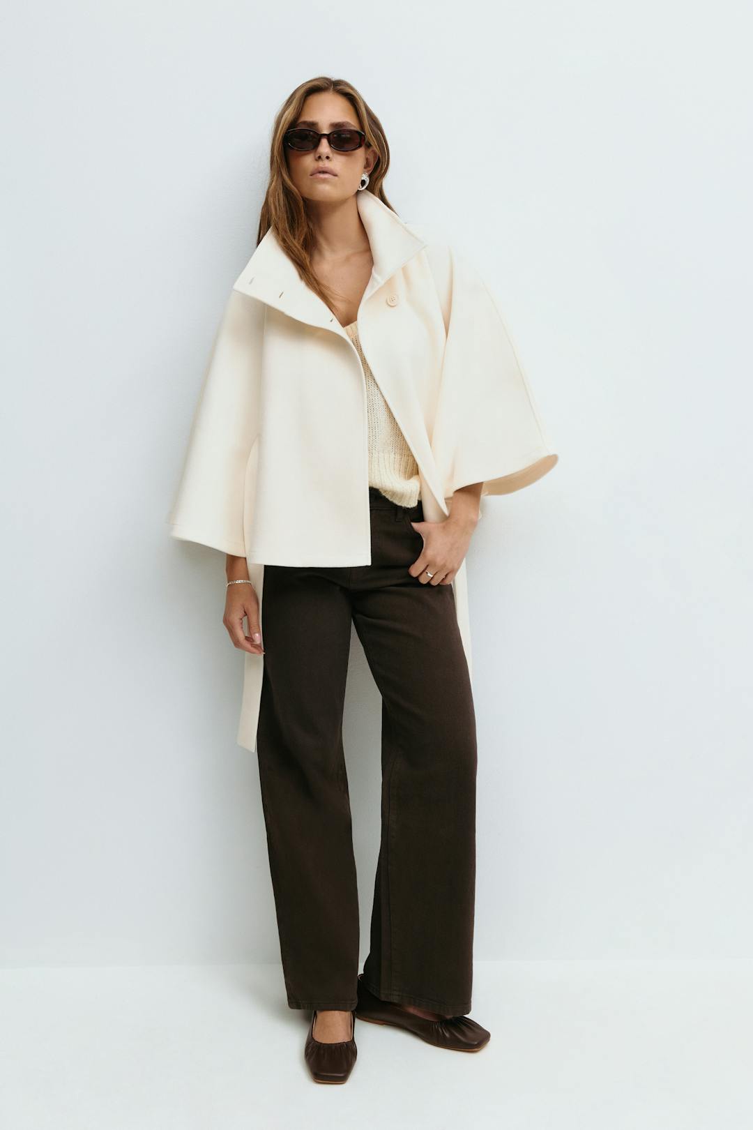 Women’s cape coat with high collar, tie belt, and regular fit